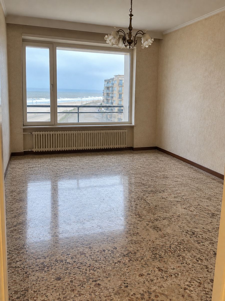 Le salon de l’appartement après débarras, pièce vide et claire, sol balayé